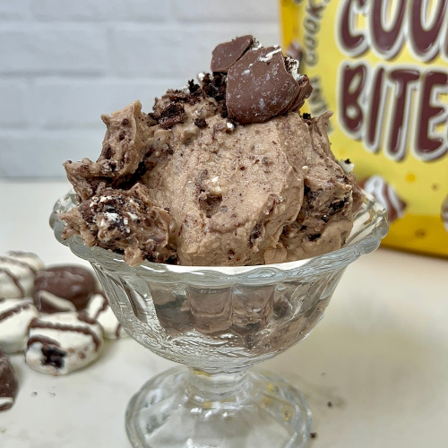 Glass dish of cookies and cream crumbled ice cream topped with chocolate cookie pieces