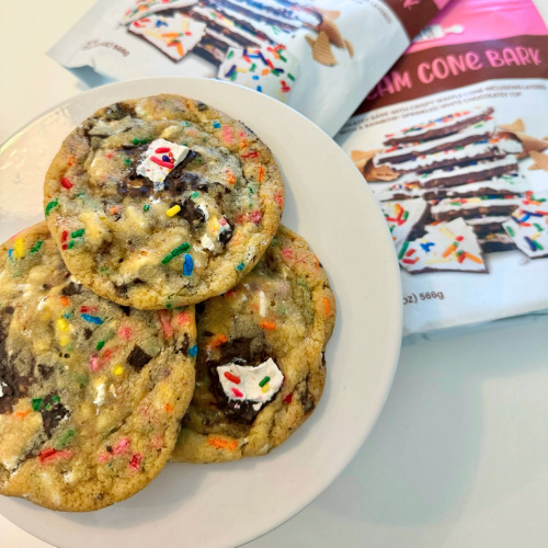 Large golden cookie studded with rainbow sprinkles and ice cream cone bark pieces