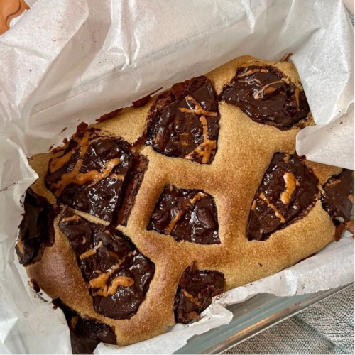 Tray of blondies topped with sea salt caramel pretzel bark and peanut butter drizzle